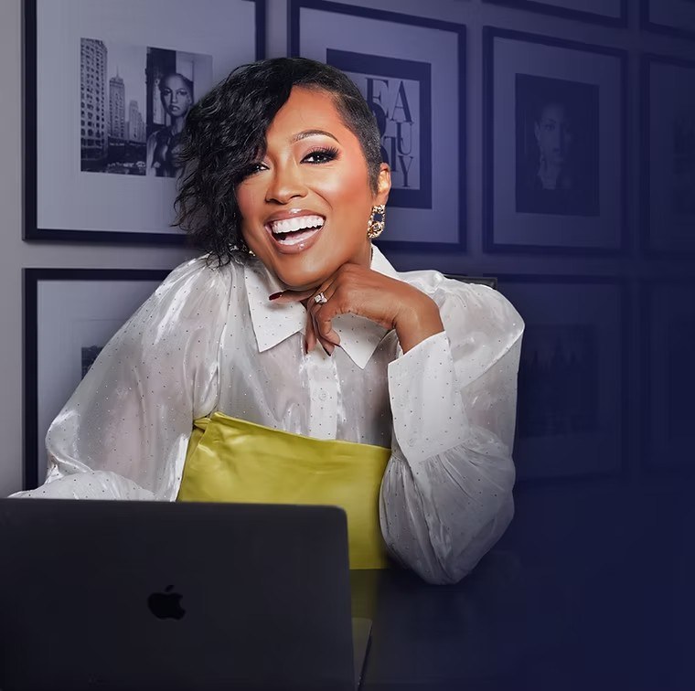 Dr. Mia Young laughing at her desk with a laptop